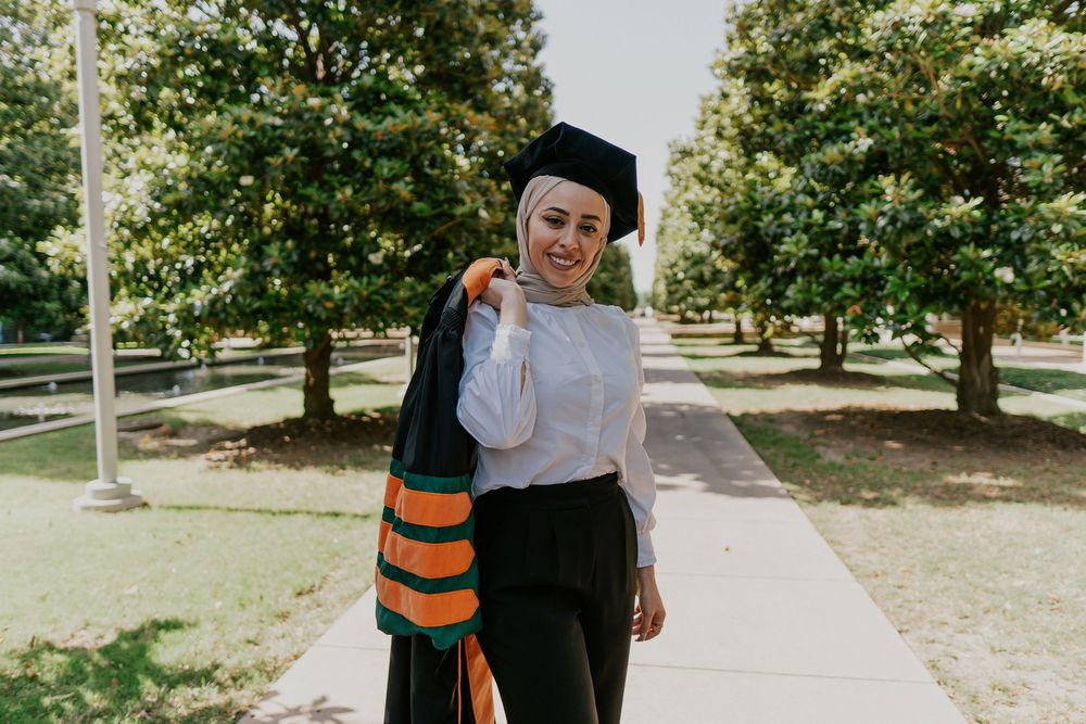 Graduate portrait session outdoors with trees and natural lighting in the background. UTD Graduate Portraits by Eric Aaberg Photography in D
