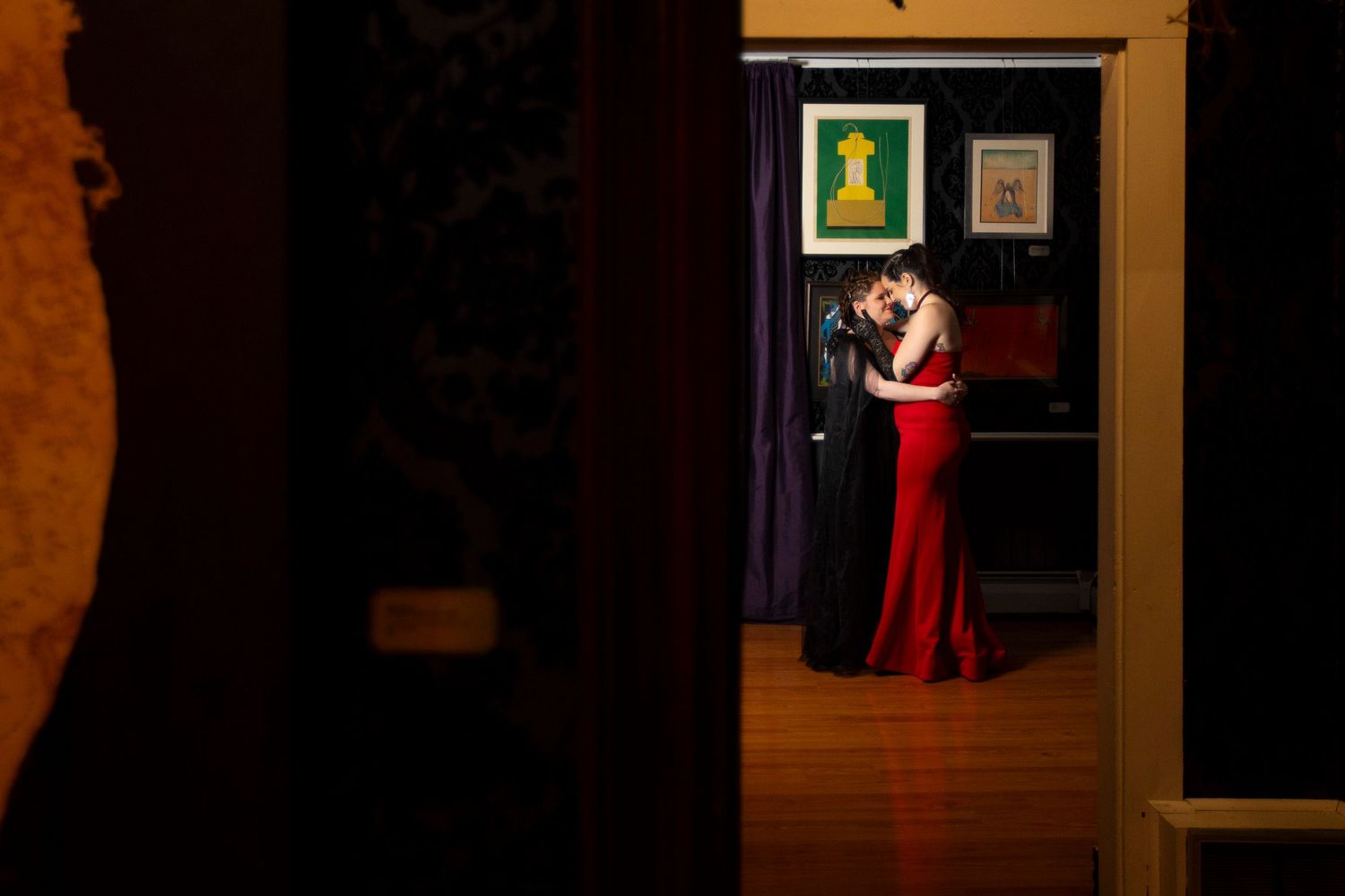 A lesbian couple hold each other in a room of an art museum after they elope.