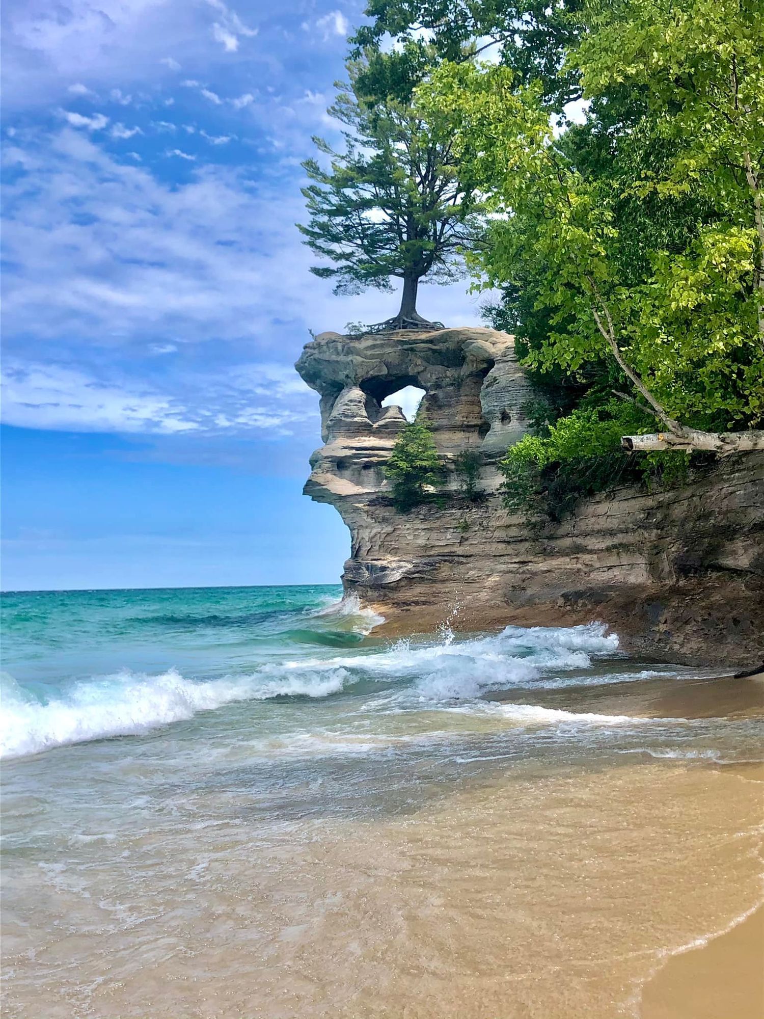 Scenic beach landscape with rocky cliffs and turquoise waters at Chapel Rock at Pictured Rocks National Lakeshore in the Upper Peninsula.