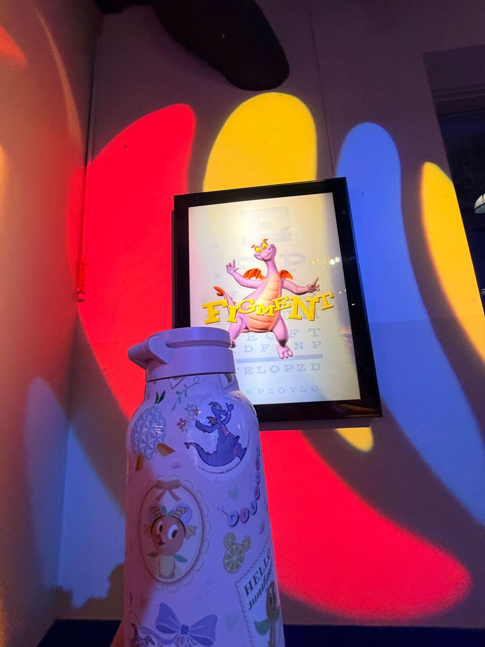 Colorful lighting display shows animated characters projected on curved white walls with red and blue spotlights.