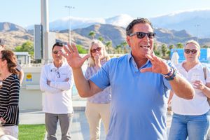 Man speaking to a group outdoors at a community or business event in the Coachella Valley