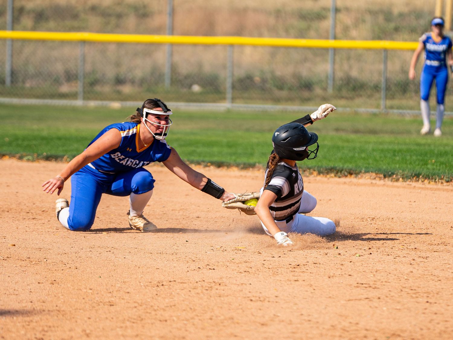 Two softball players in action during a close play at second base.