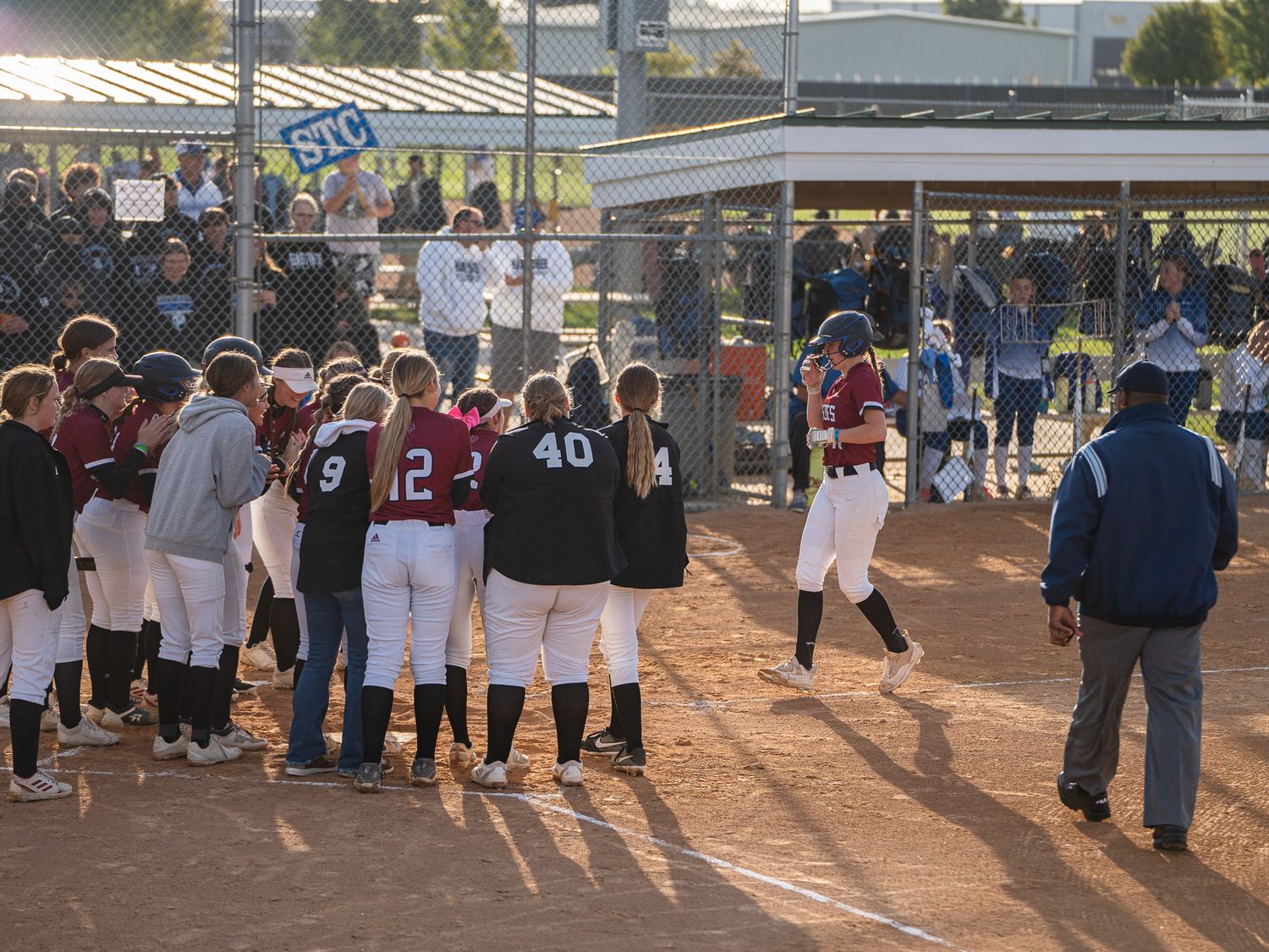 Teams gather home plate to celebrate a home run