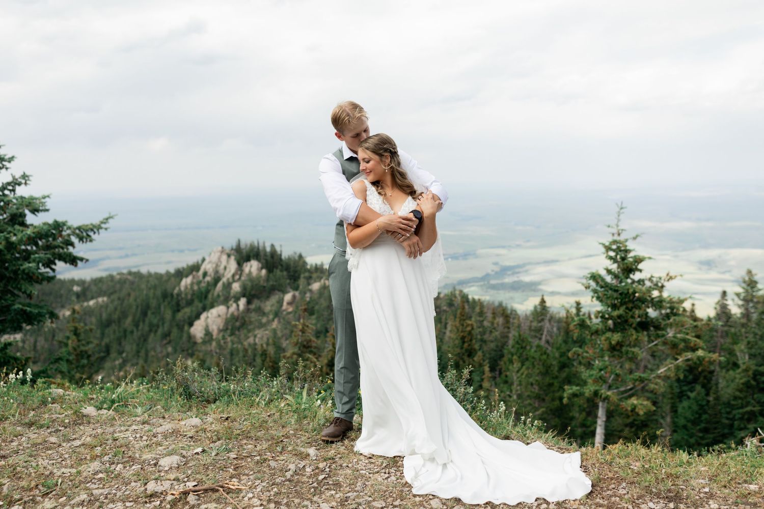 Couple embracing cliffside on top of a mountain in Montana.