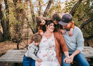 Happy family sharing a tender moment on a rustic bench in autumn woods.