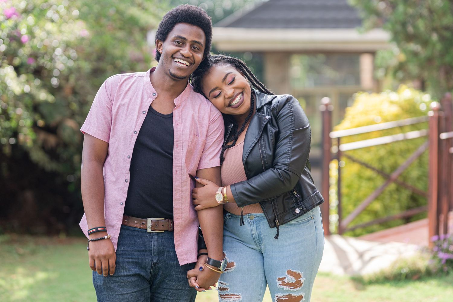 Portrait of a couple standing next to one another, in garden. Woman's head leaning on man's shoulder. Ikigu George Photography.
