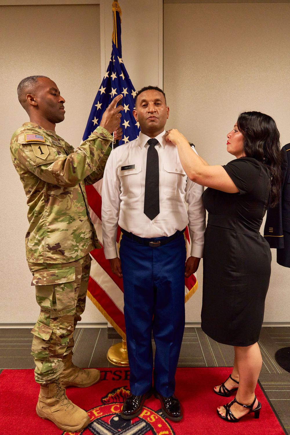 Military promotion ceremony with service members adjusting uniform insignia.