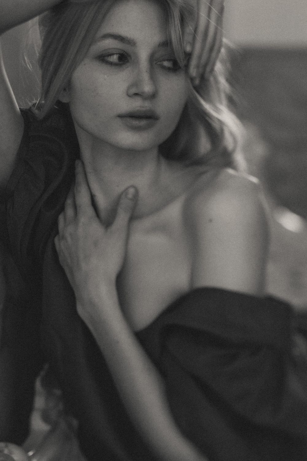 Moody black and white portrait with soft lighting and dramatic shadows.