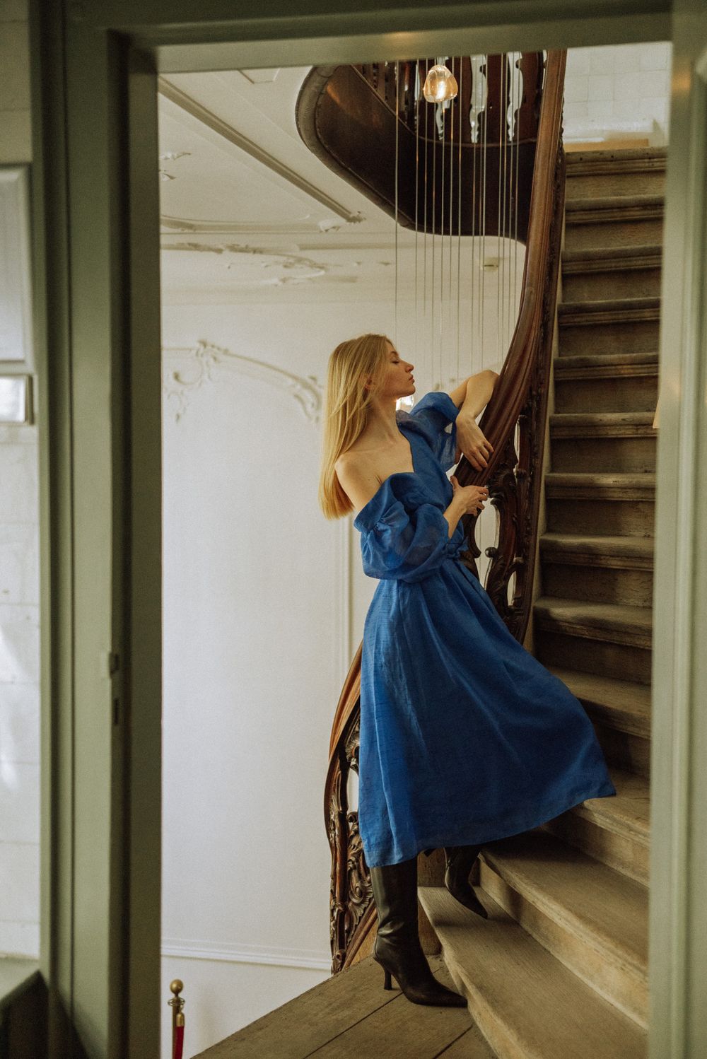 Artistic shots on a white staircase showing movement in a flowing blue dress.