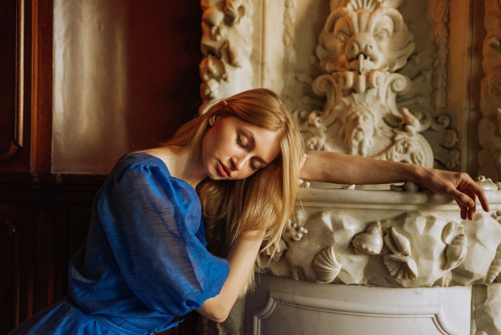 Soft portraits against ornate wall details in dramatic afternoon light.