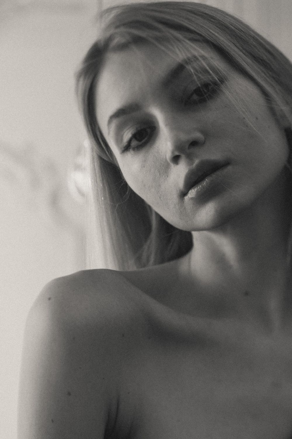 Intimate black and white close-up portrait with natural window light.