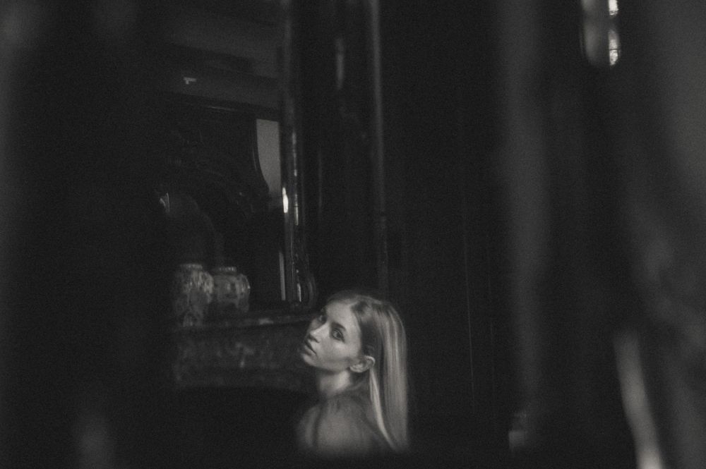 Atmospheric black and white portrait with dramatic shadows and reflections.