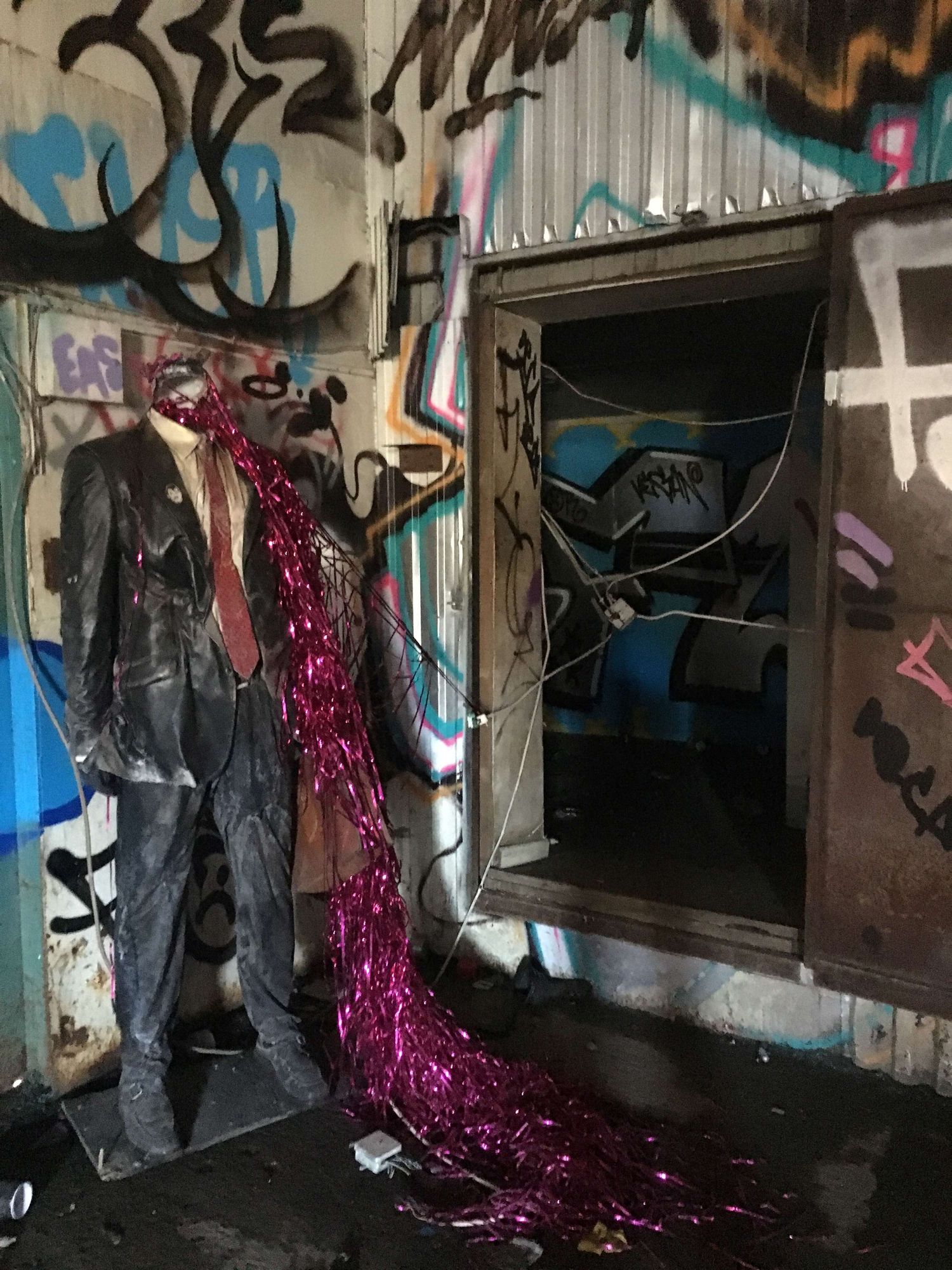 Graffiti and a mannequin in a costume.