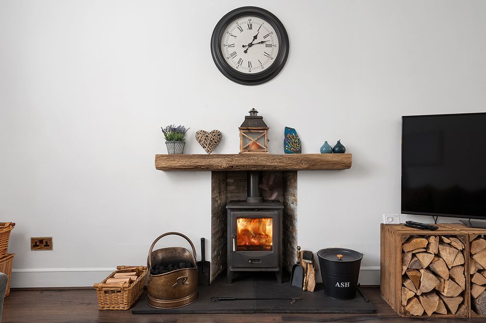 lounge with log burner and wood store. Estate agent photograph.