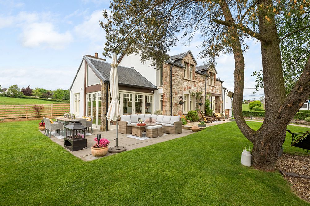 Exterior photograph of large country house with extensive front and rear gardens and separate bar area. Falkirk estate agents.