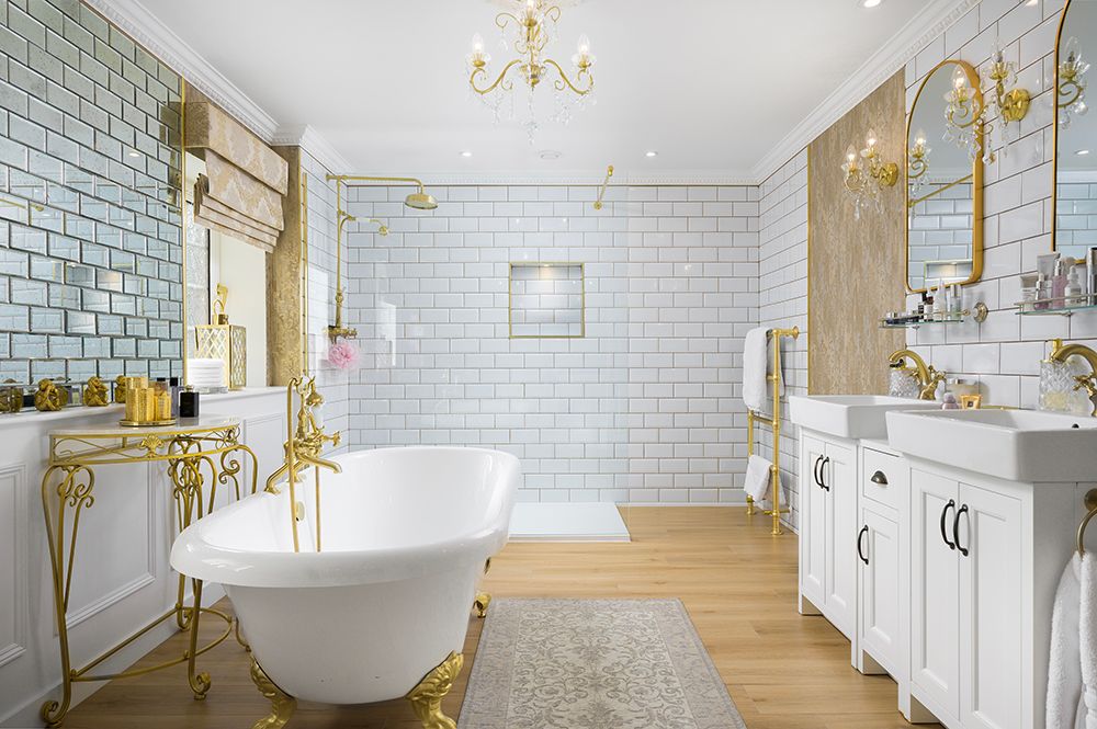 Large master bathroom with roll top bath, separate shower cubicle and tiled walls.
