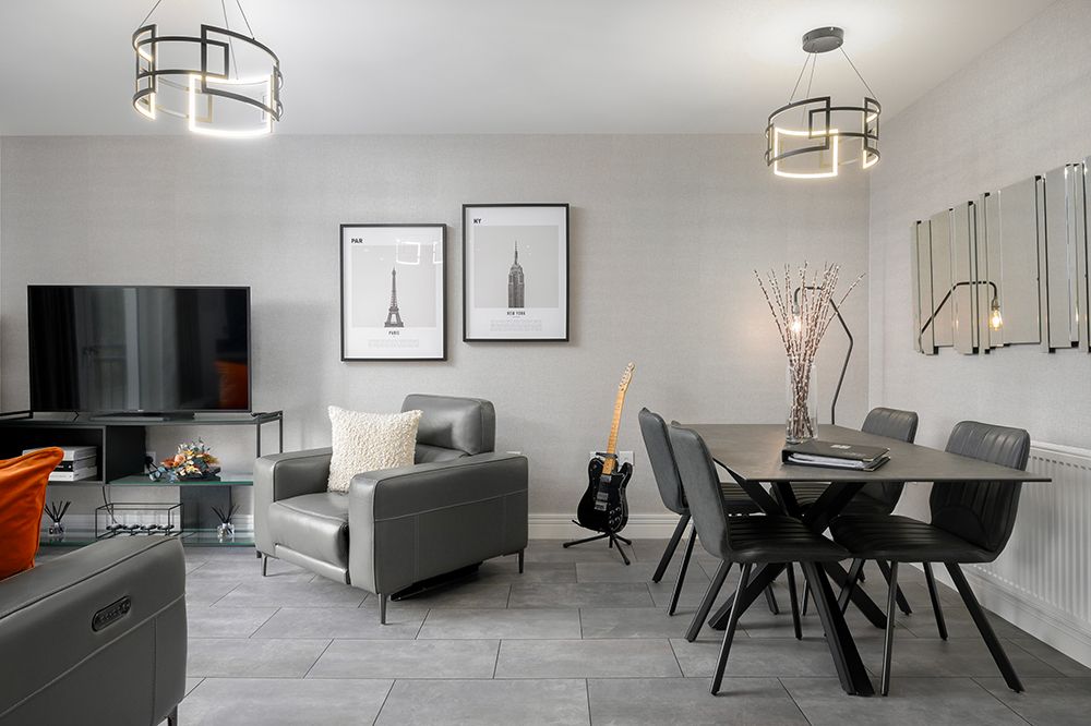 Modern open plan living area with dining space and grey furninshings.