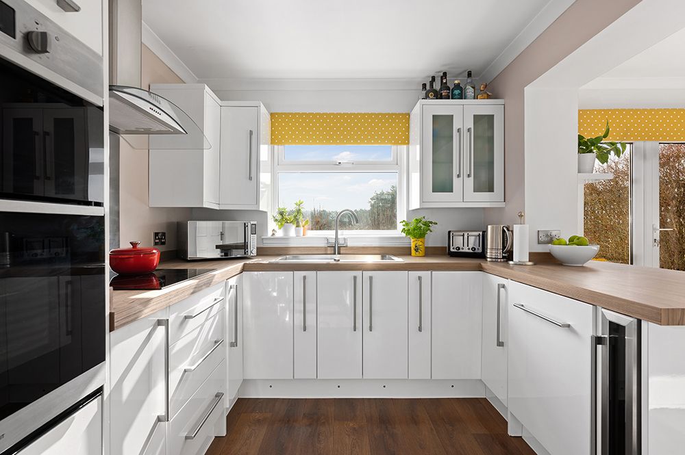 white and yellow kitchen with modern finishes. double oven and dishwasher integrated. Kitchen company photoshoot.