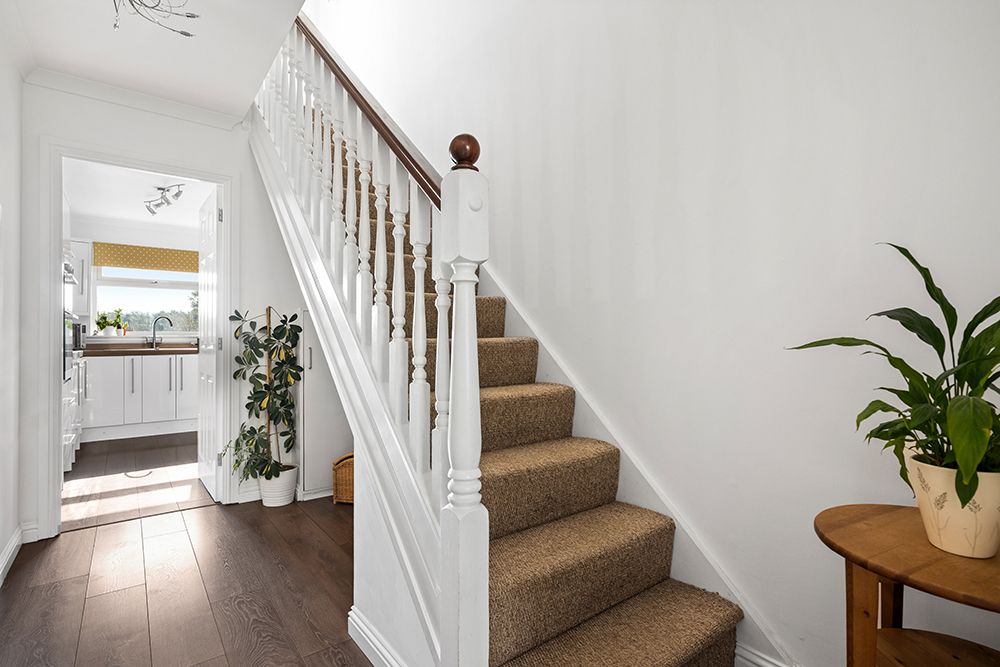 entrance hallway to family home in stirling showing kitchen and carpeted stairway to upper level.