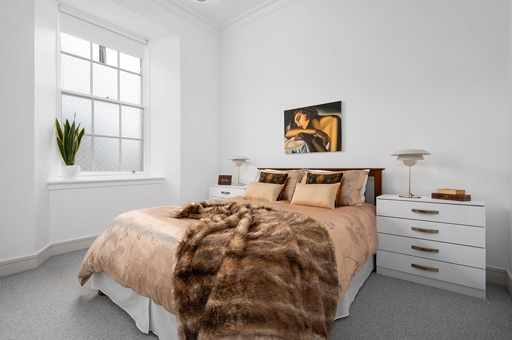 extensive master bedroom in white with colourful accessories