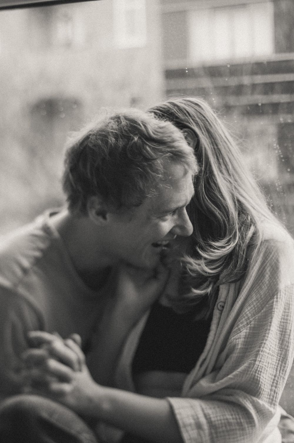 Black and white intimate portrait capturing tender embrace.