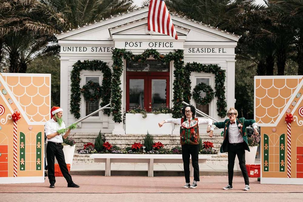 American flag flies above decorated post office building during holiday season.
