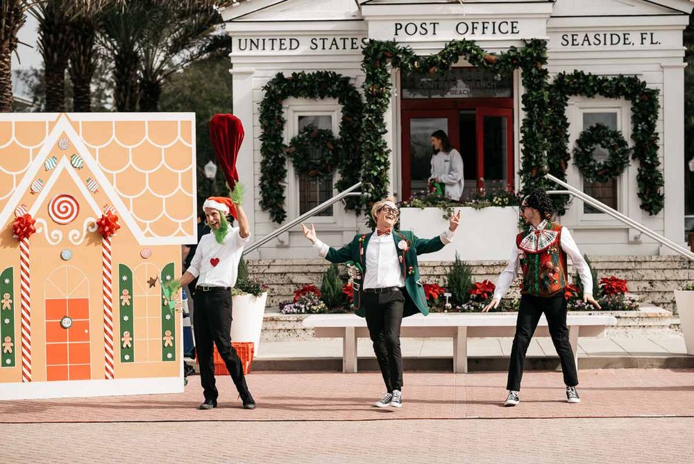 Group performs synchronized dance moves outside a festive post office with holiday decorations.