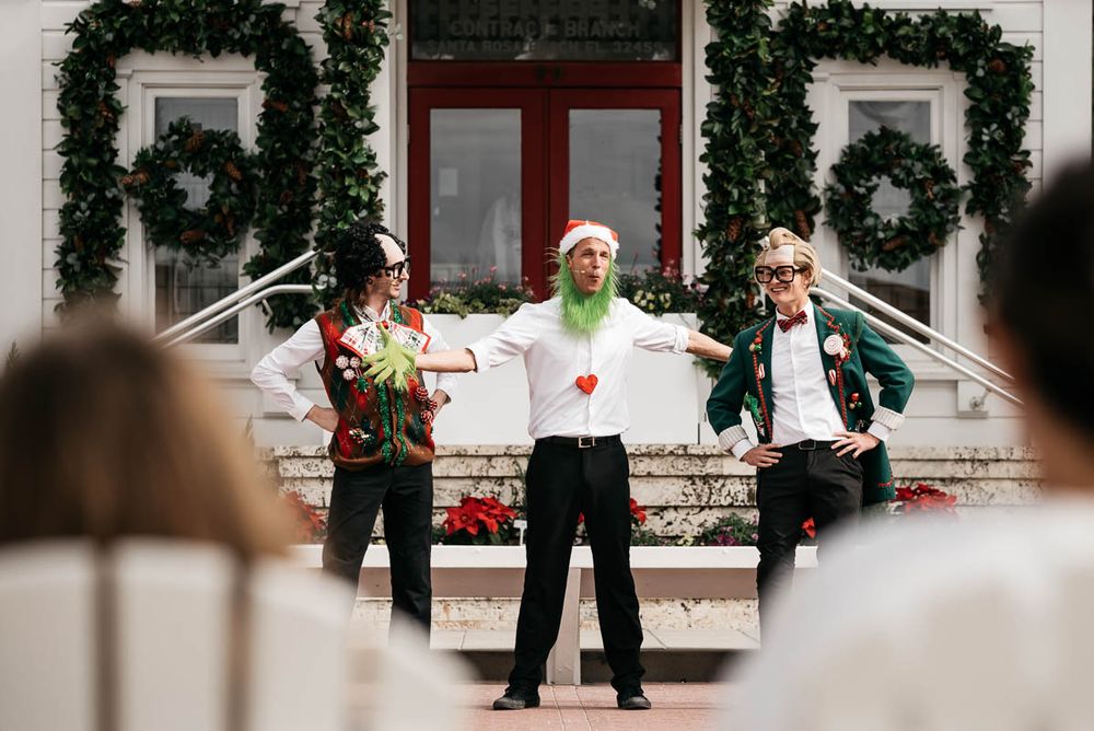 People gathering outside a festively decorated post office with wreaths and garland.