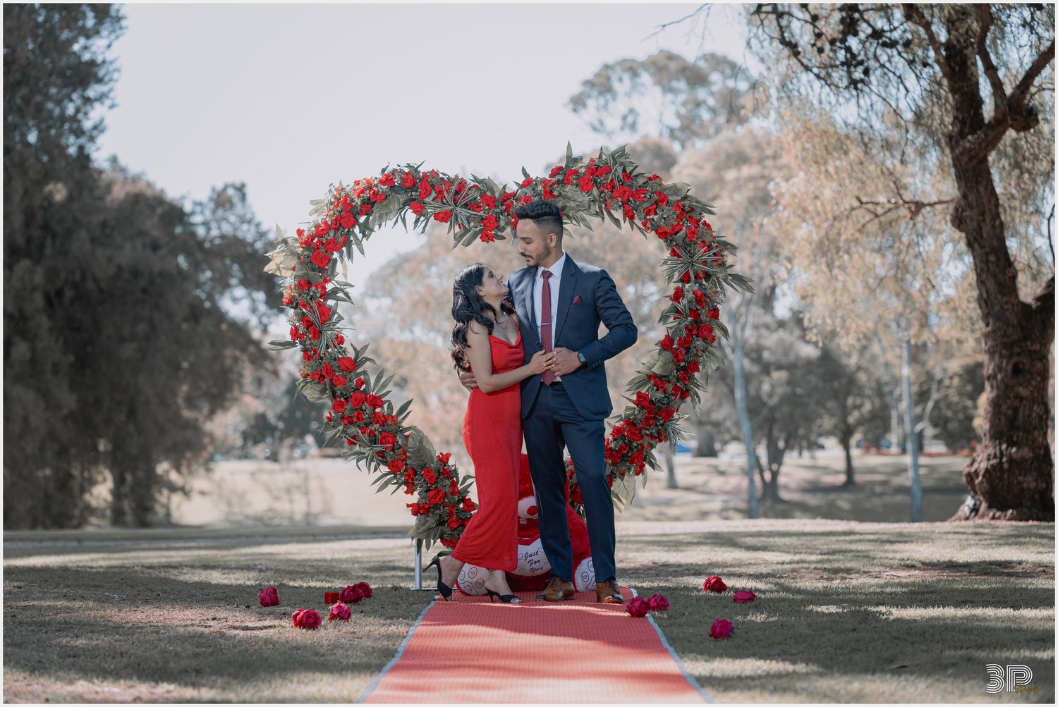 Man proposing to his partner in a romantic outdoor setting, with the moment captured in a heartfelt and intimate photo.