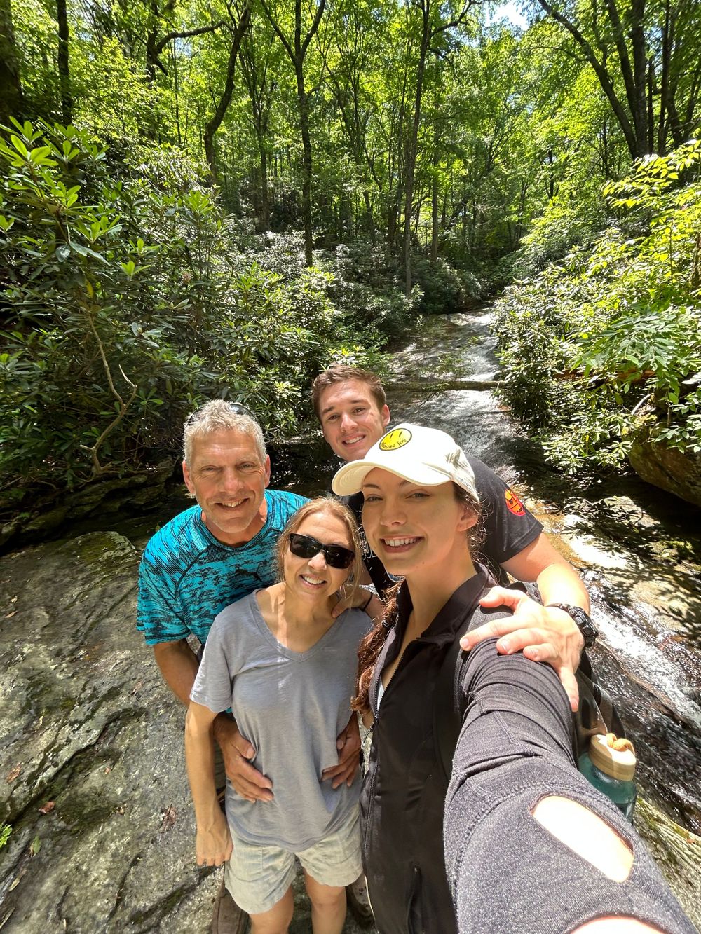 Group taking a selfie while hiking on a scenic wooded trail.