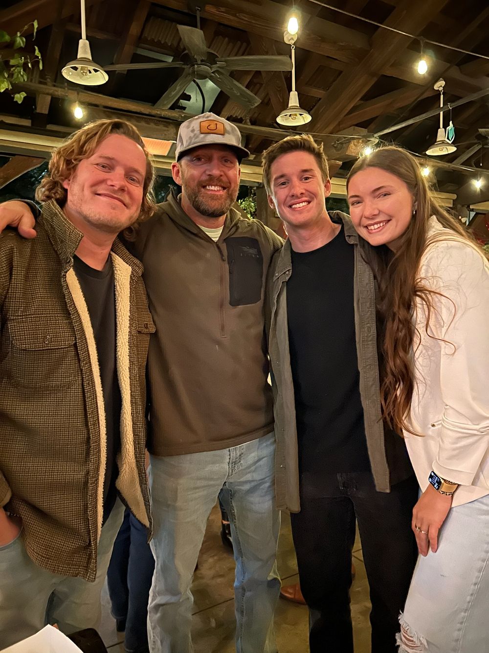 A group of friends posing together at a casual indoor gathering.
