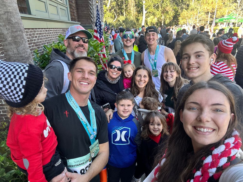 A cheerful group taking a selfie at an outdoor community event.