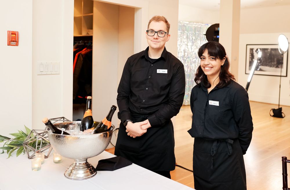 Catering staff standing behind service table at an elegant event.