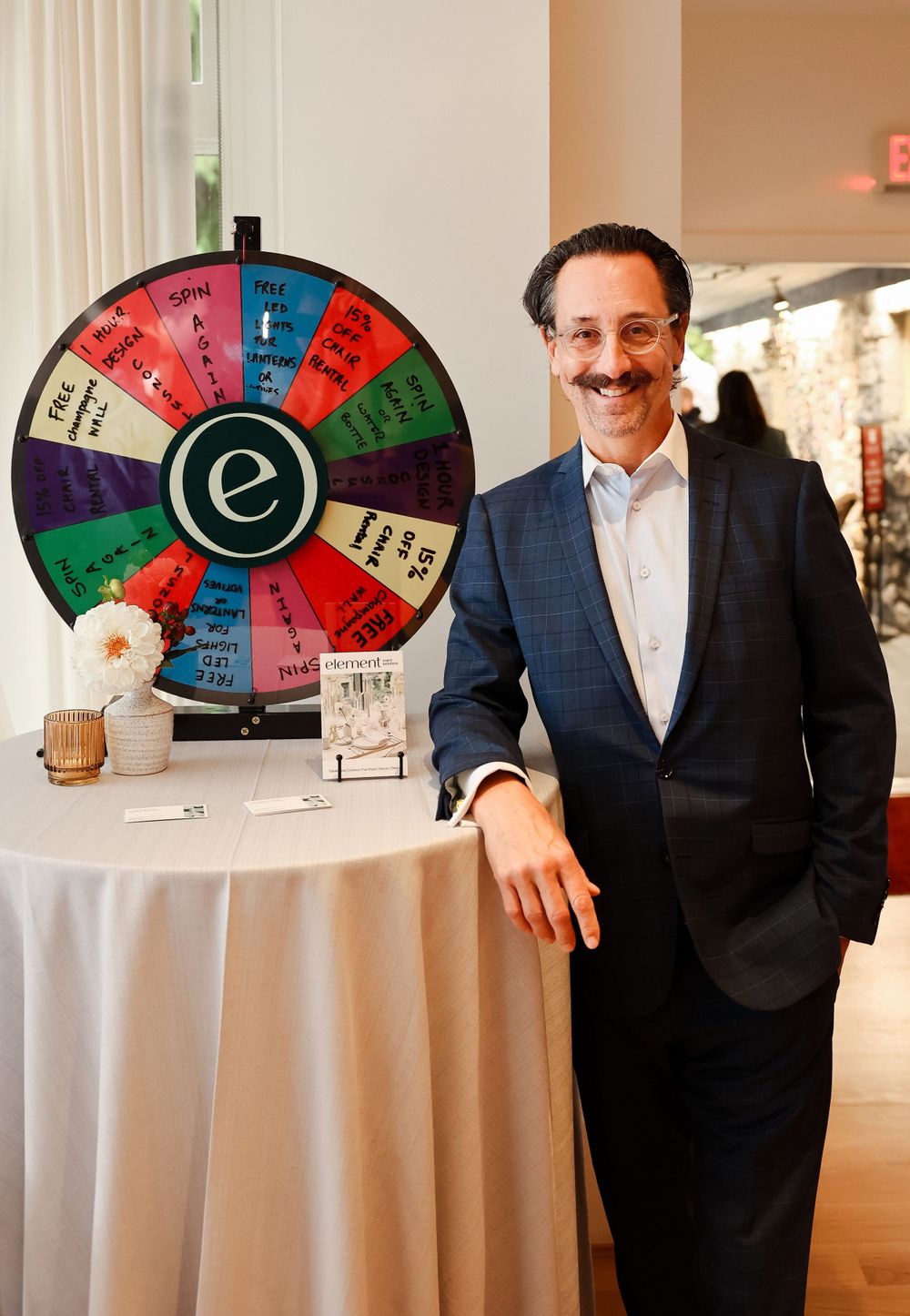 Promotional prize wheel display setup on round cocktail table at corporate event.