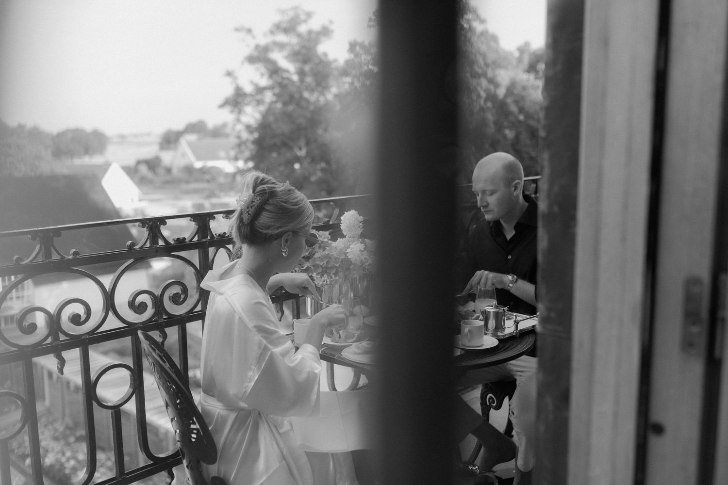 Bride and groom sharing an intimate breakfast on a sunlit balcony at Maryhill Estate, Sweden – a quiet moment before their wedding day.