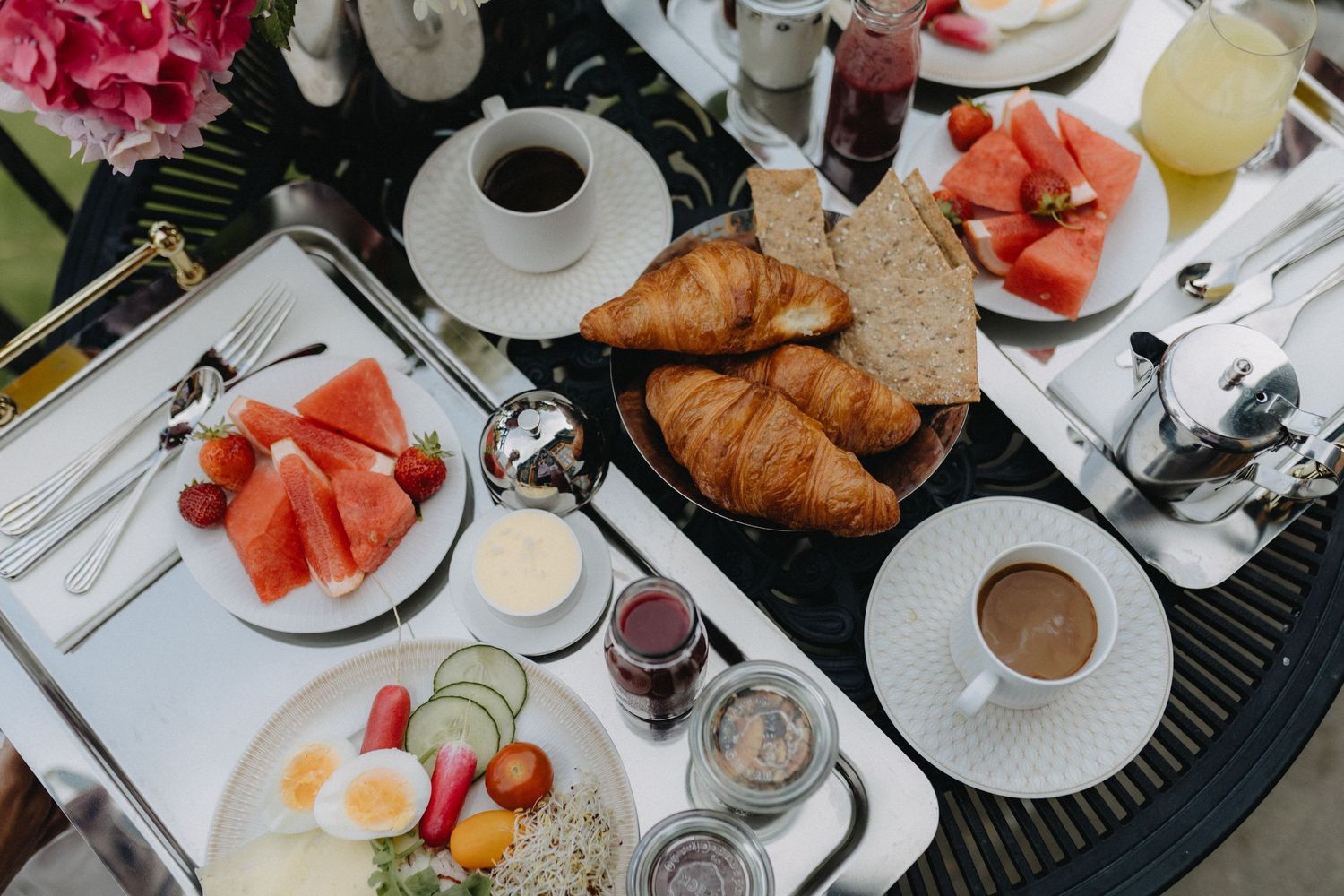Luxurious breakfast spread with croissants, fresh fruit, eggs and coffee on a table at Maryhill Estate, Sweden.
