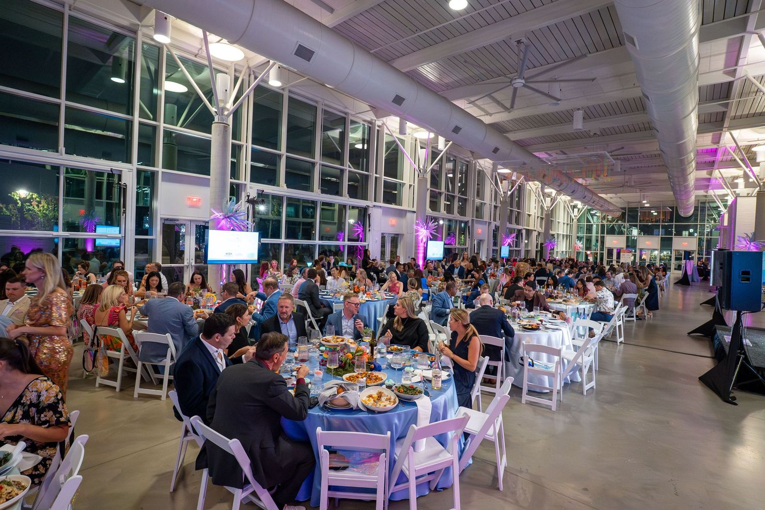 Panoramic view of a modern restaurant interior with white tables and chairs under bright lighting.