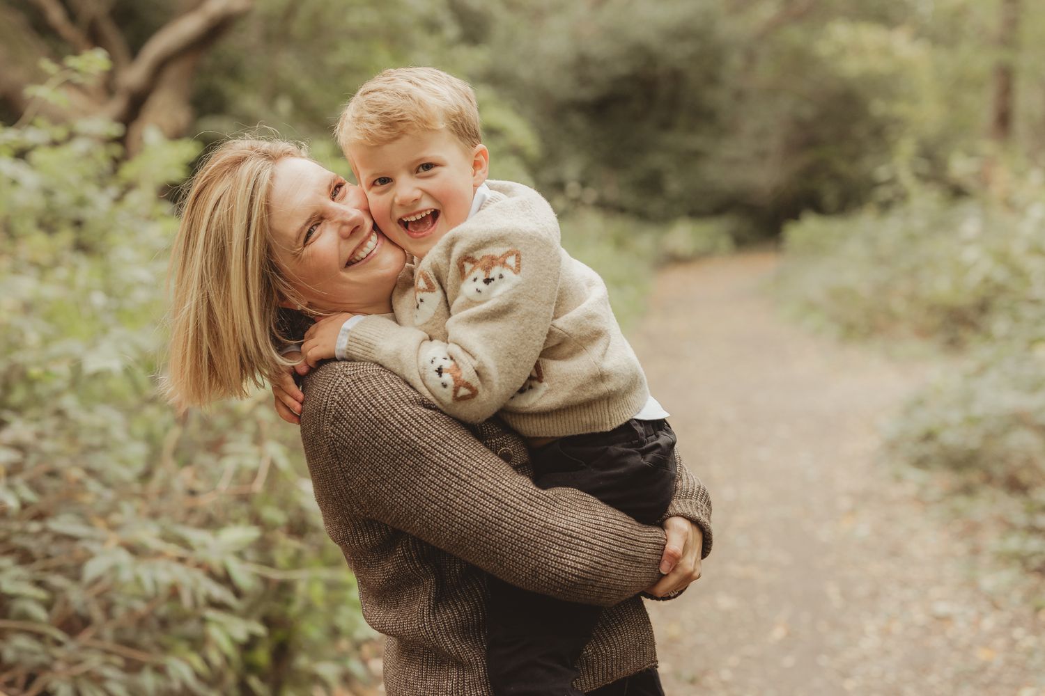 Candid family moments captured on a nature trail with golden lighting.