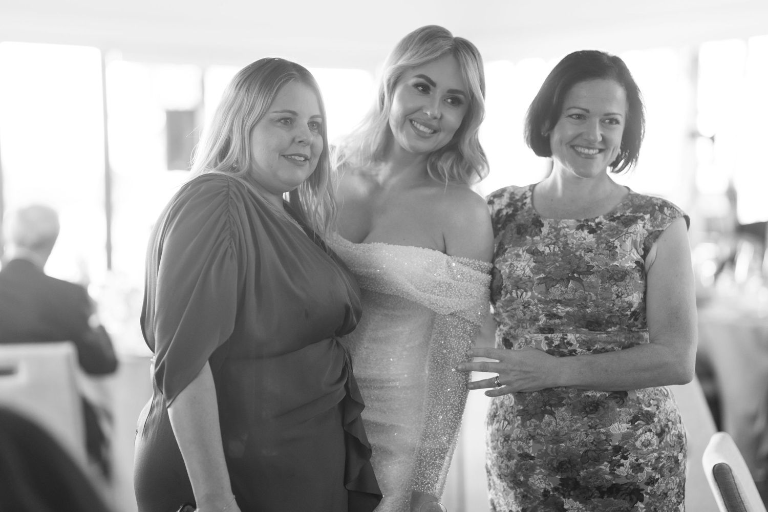 A collection of candid black and white wedding photos showing joyful moments between people during a celebration.