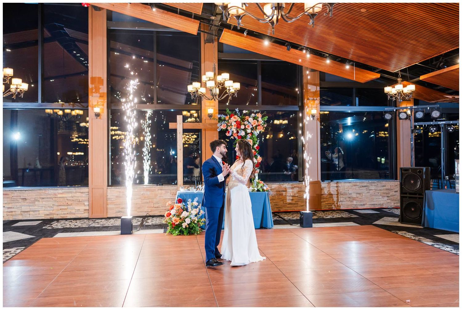 Spacious indoor wedding venue with wooden dance floor and exposed ceiling beams.