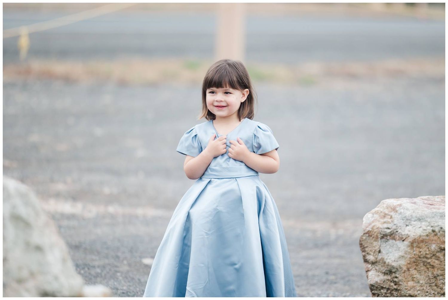 Young attendants in light blue outfits gather for formal wedding photos outdoors.