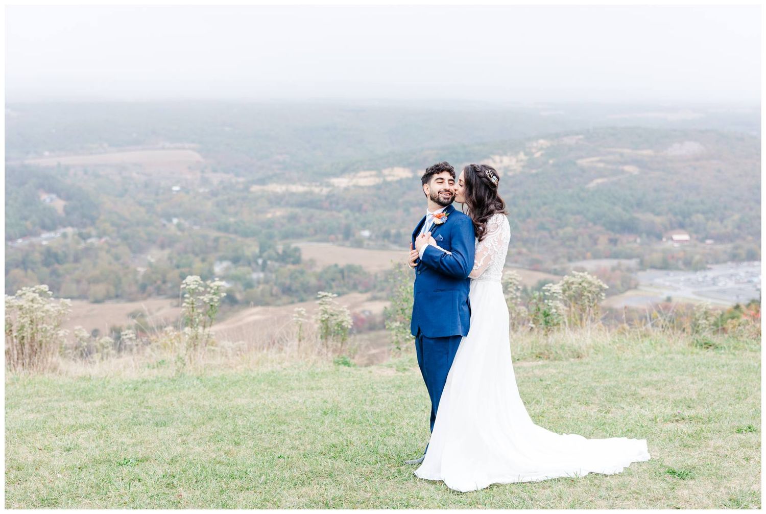 Scenic mountain view wedding portraits with couple in blue suit and white dress.