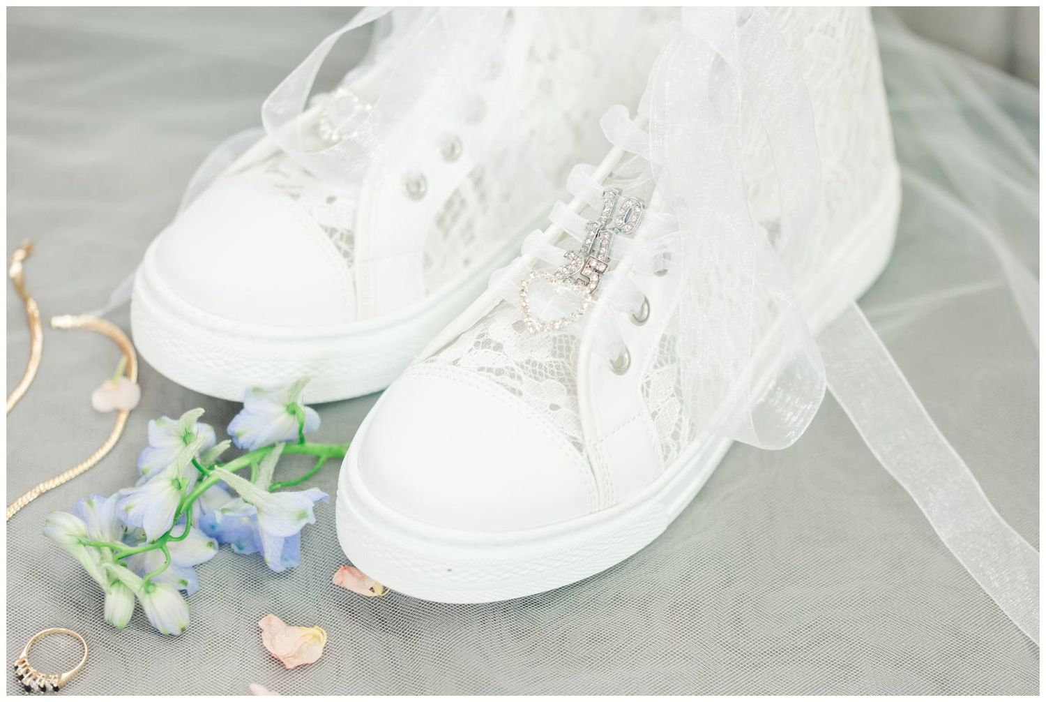 Delicate white lace details and floral decorations arranged on a light gray surface.