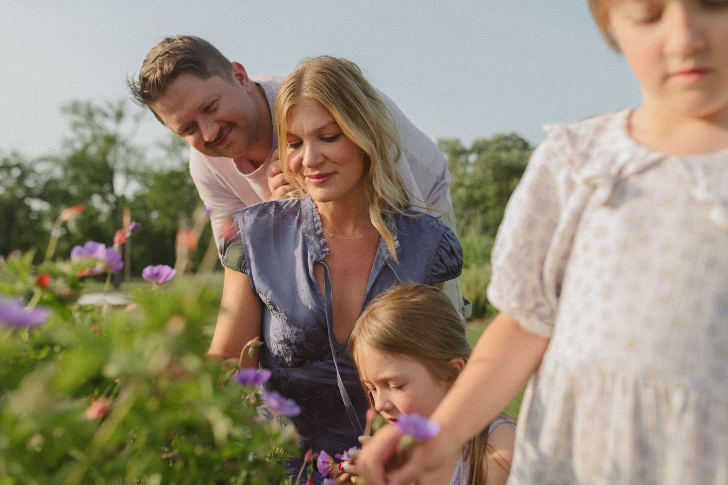 Children enjoying outdoor activities in a garden with blooming flowers.