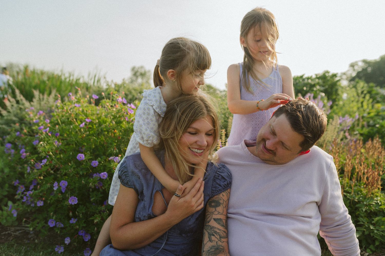 Family sharing joyful moments together while sitting in a blooming flower field.