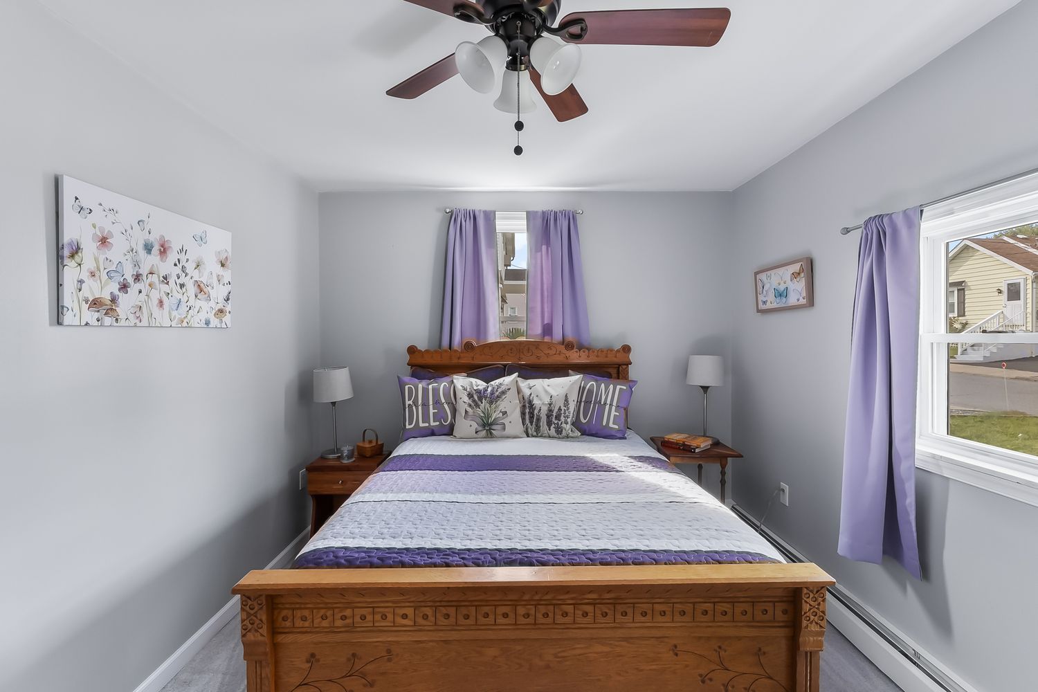 Modern bedroom interior with purple accents, ceiling fan, and natural lighting.