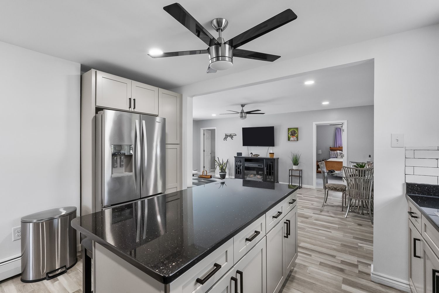 Modern kitchen with ceiling fan, recessed lighting, and stainless steel appliances.