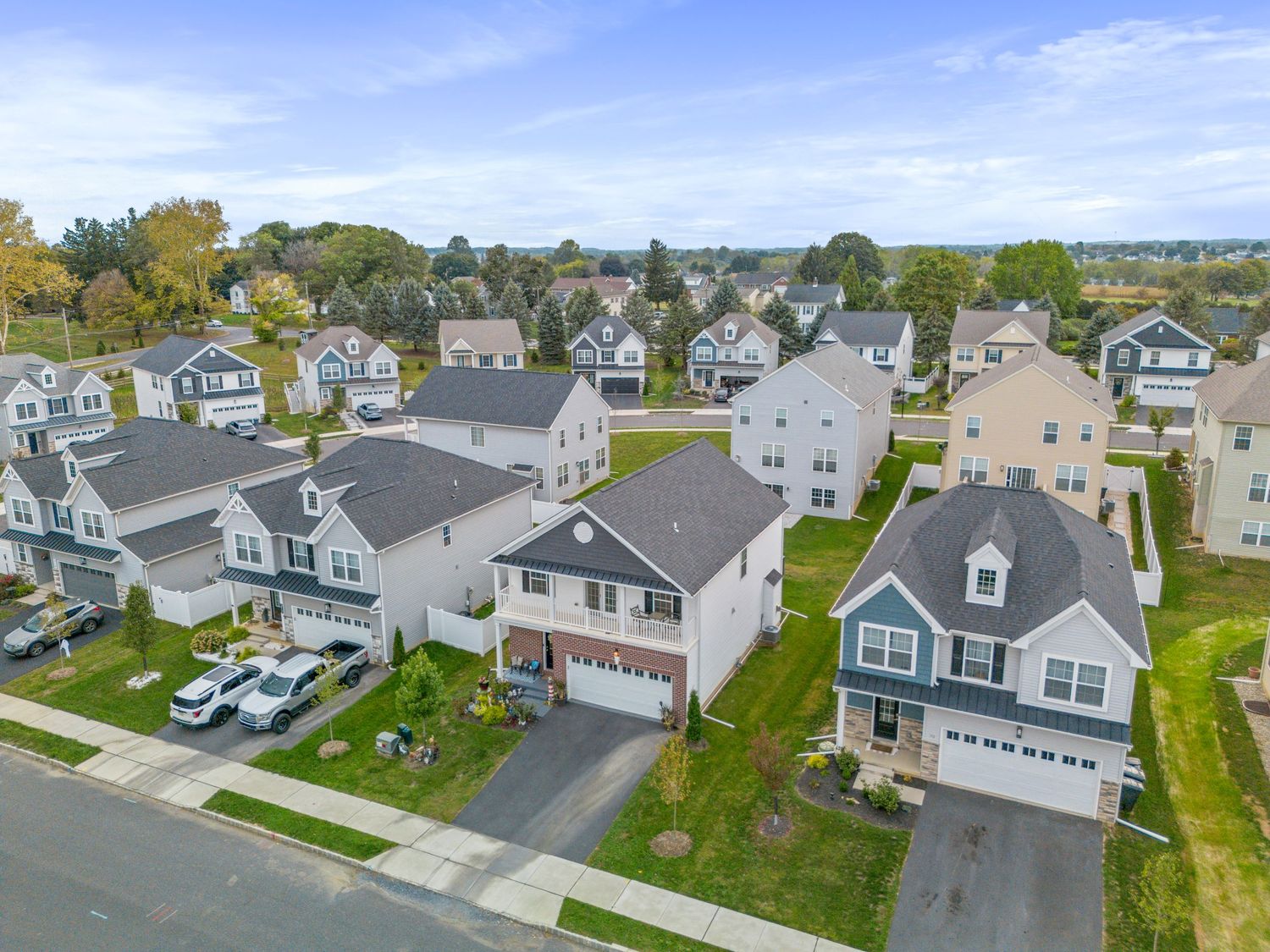 Drone shot of residential street with two-story homes and attached garages.