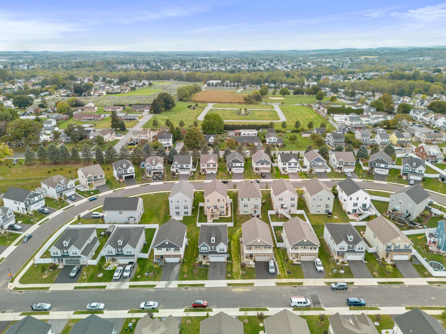 Aerial view of suburban neighborhood with neatly arranged houses and green lawns.