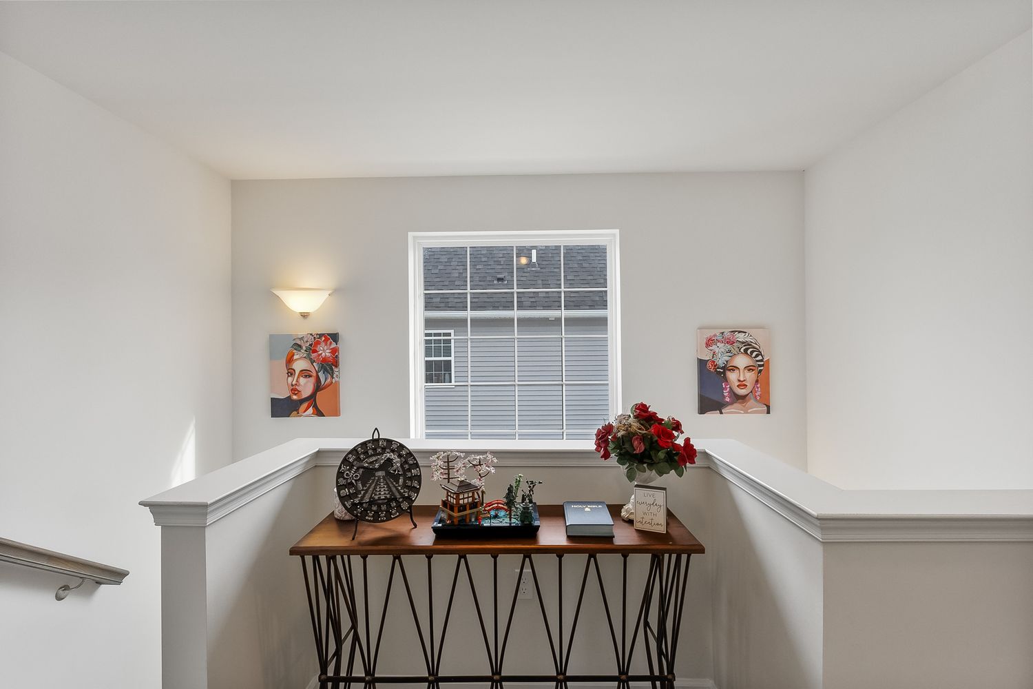 Modern interior hallway with white walls, hardwood floors and decorative console table with fall decor.
